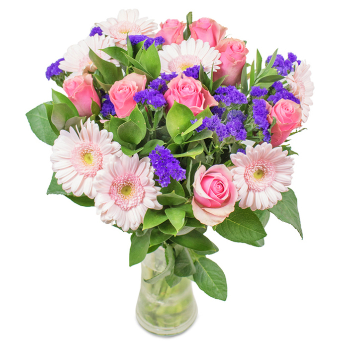 This vibrant, sophisticated bouquet from Norbury Florist stands in a crystal-clear vase, set against a luminous white background reminiscent of a freshly painted Norbury shopfront. At its heart, seven to nine soft- to medium-pink roses unfold-some tightly coiled, some just beginning their elegant reveal-each displaying a unique spiral. Around them, five to seven pale pink gerbera daisies contribute expansive, round faces with near-white centres, lending a gentle, glowing lightness to the mix. Throughout, brilliant purple clusters of statice or limonium offer lively bursts of saturation and texture, drawing the eye and providing dramatic contrast. Dense, emerald-green leaves form a luxurious base, imbuing the bouquet with a sense of abundance and garden freshness. Through the transparent vase, every stem's line and the glimmer of pure water are visible, ensuring the bouquet's natural grace is on full display. This lovingly crafted arrangement suits many of life's occasions-Mother's Day, birthdays, or welcoming a new arrival in Norbury-carrying an atmosphere of joy, warmth, and affection throughout homes or local businesses in this spirited community.